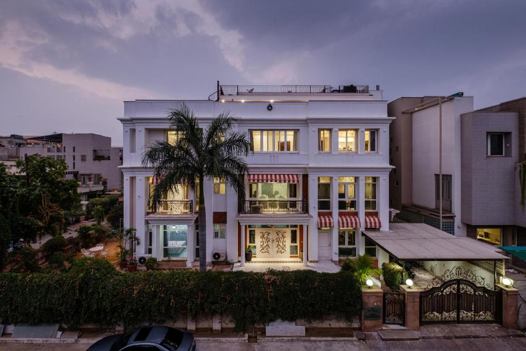 uma casa branca com uma palmeira em frente em Palm 34 em Jaipur