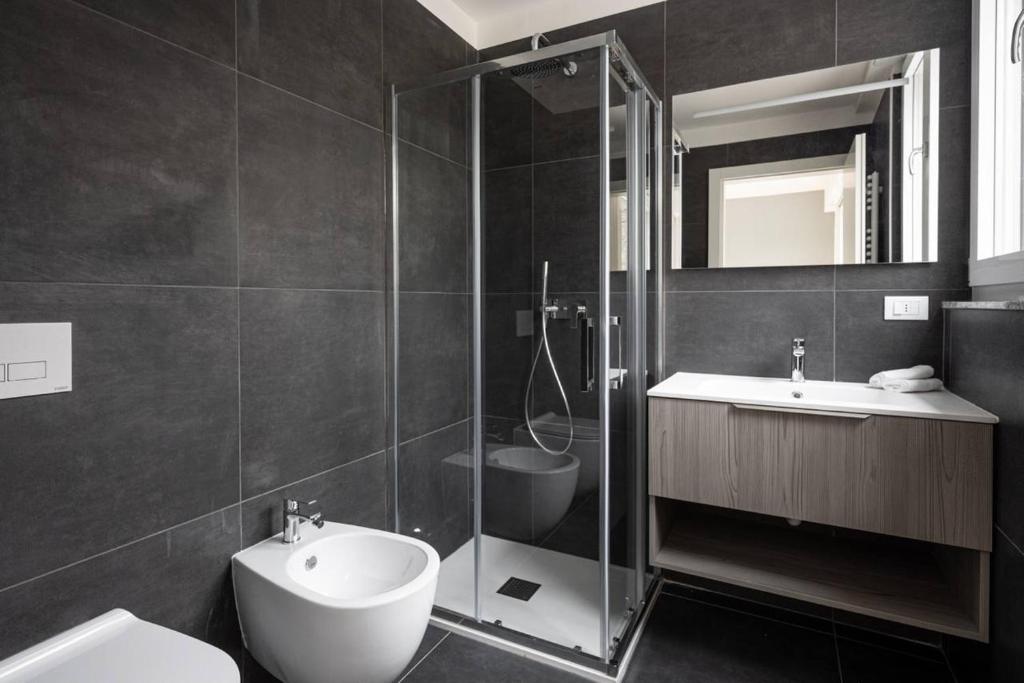 uma casa de banho com um chuveiro, um lavatório e um WC. em Casa Kaleido em Trento