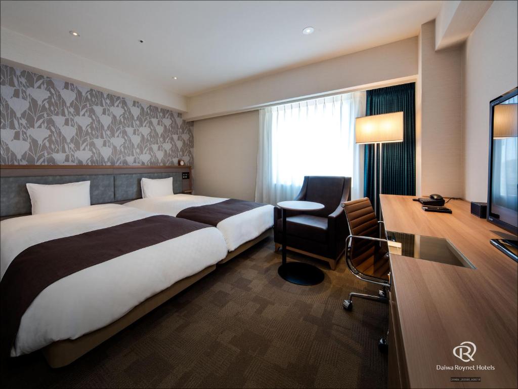 a hotel room with a large bed and a desk at Daiwa Roynet Hotel Tokushima Ekimae in Tokushima