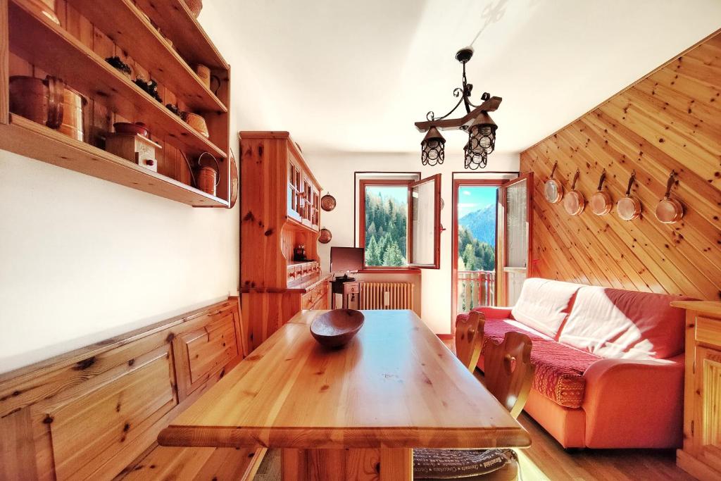 uma sala de estar com uma mesa e um sofá em - La Casetta di Legno - i colori della natura em Foppolo
