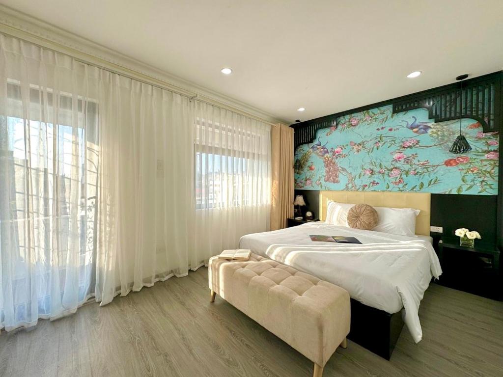 a bedroom with a large bed and a large painting on the wall at Hanoi Elpis Hotel in Hanoi