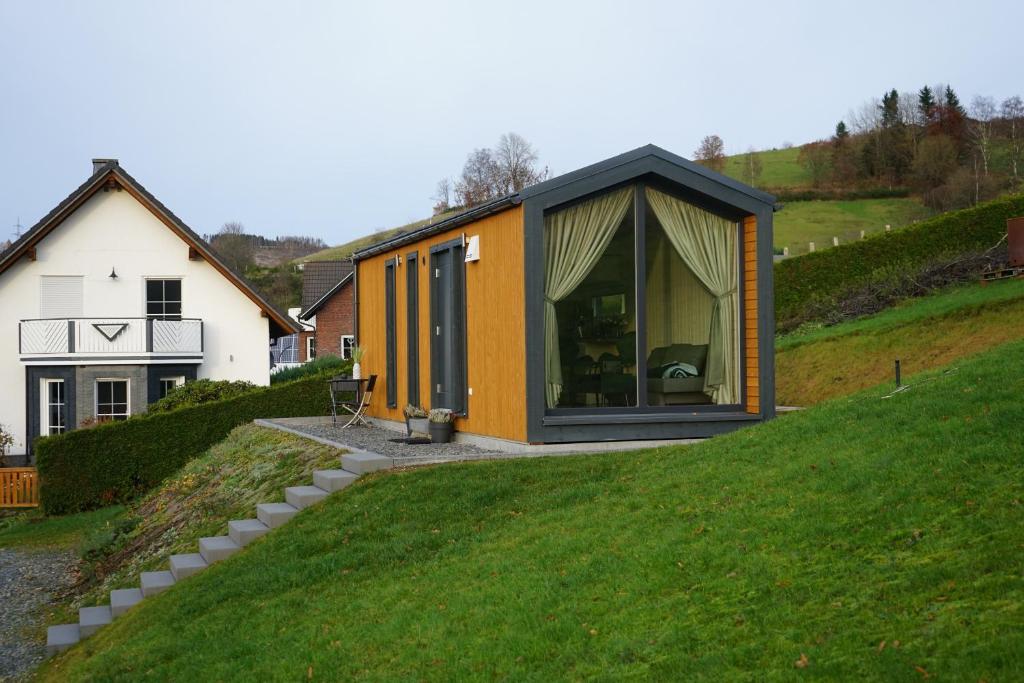 a house on top of a grassy hill at Tinyhouse Heimatglück in Bad Berleburg