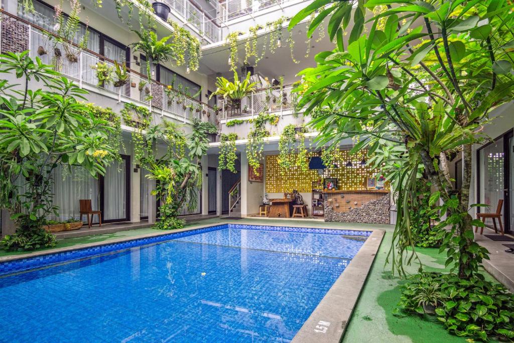 a swimming pool in the middle of a building with plants at Roemah Kenari in Jetis
