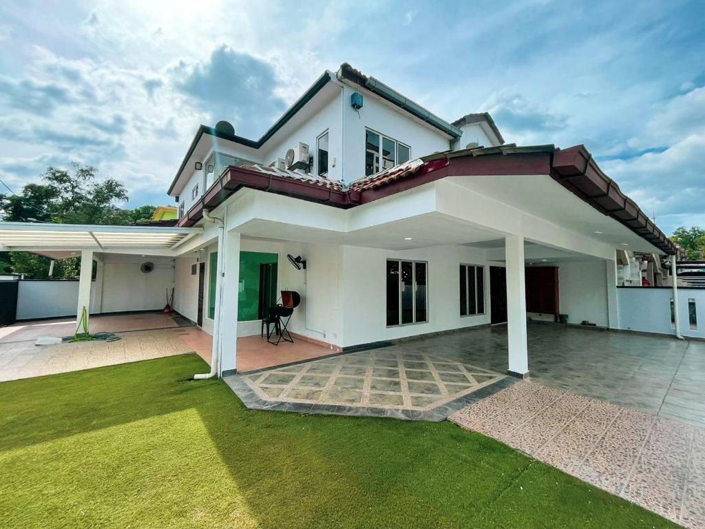 una grande casa bianca con un prato verde di Luxury Homestay, MahkotaCheras, Gaming, Gathering a Cheras