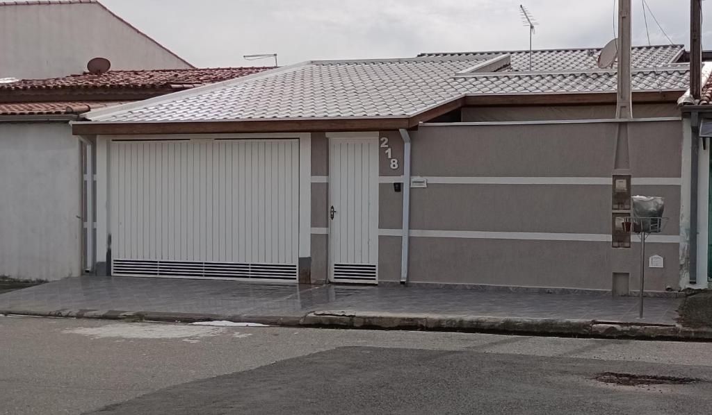 una casa con dos puertas de garaje en una calle en Casa da Nice, en Guaratinguetá