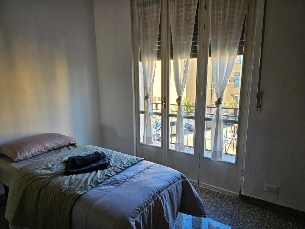 a bedroom with a bed and a large window at Camera Alex in Pavia