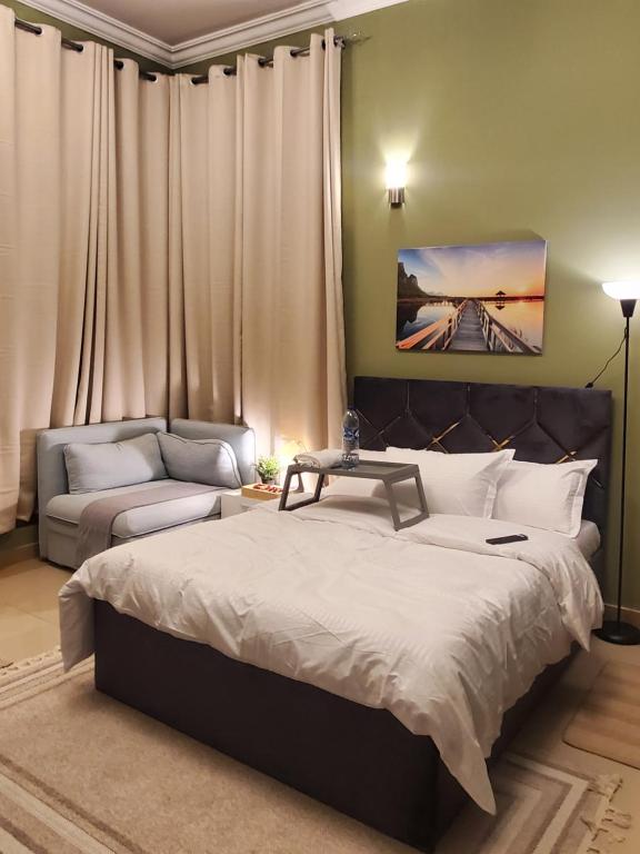 a bedroom with a large bed and a couch at Cozy private room near World Trade center and metro in Dubai