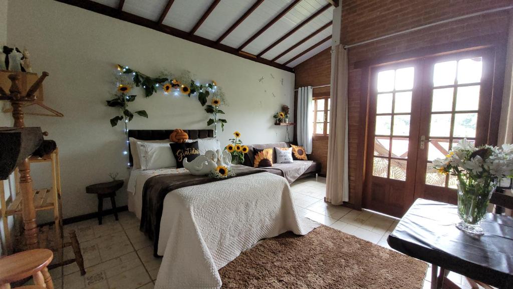 um quarto com uma cama e um sofá num quarto em Chalé Paraíso Fazendinha Cachoeira Pet Friendly em Lumiar