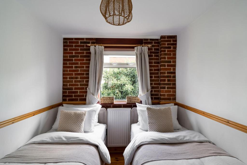 two beds in a room with a window at Pound Street in Exmouth