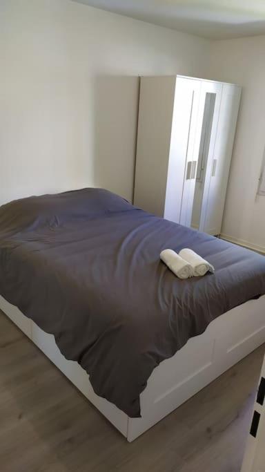 a bed in a white room with a mirror at T2 de 42m² A proximité de la gare à 30min de PARIS in Mantes-la-Jolie