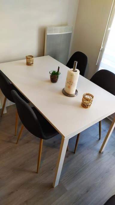 a table with two chairs and a white table with a plant on it at T2 de 42m² A proximité de la gare à 30min de PARIS in Mantes-la-Jolie