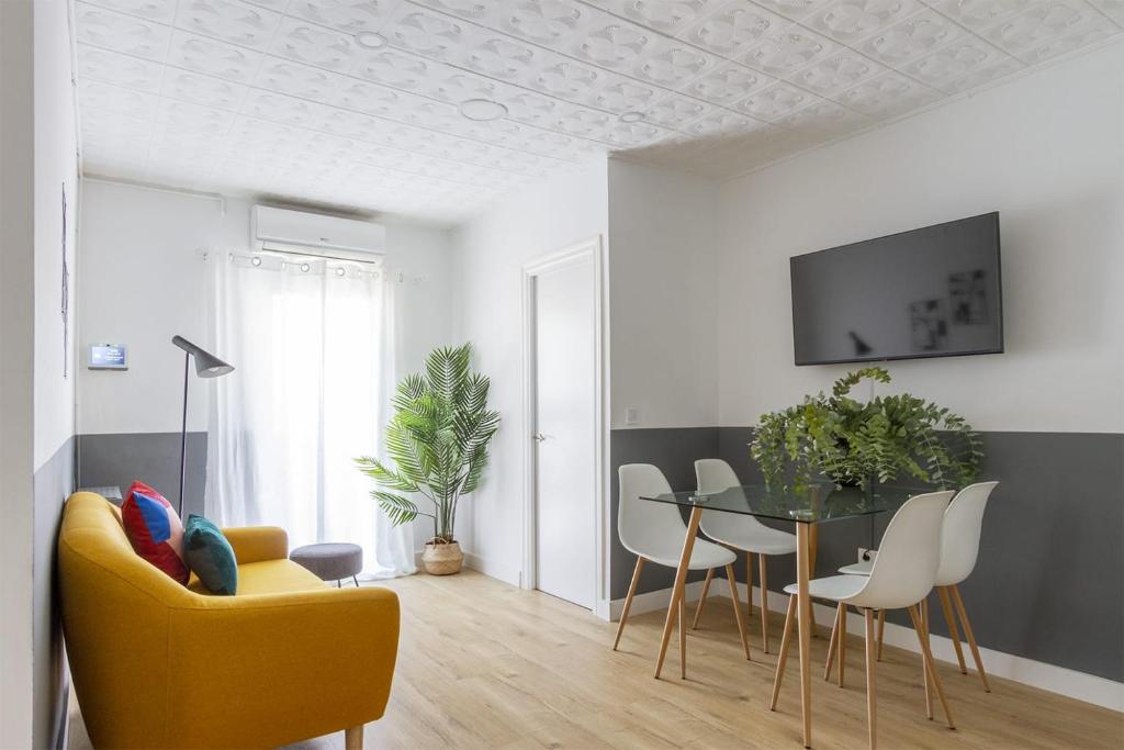 uma sala de estar com um sofá amarelo e uma mesa em Feel Welcome Barcelona # SPLAU em Cornellà de Llobregat