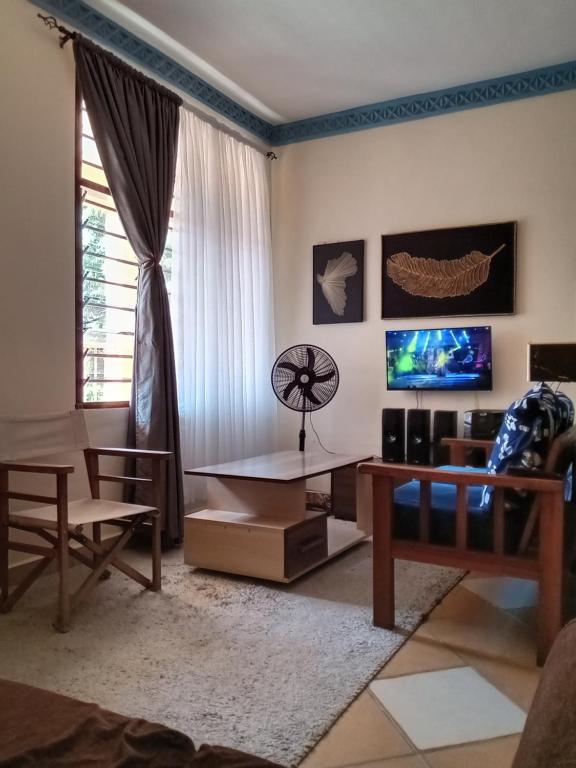 - un salon avec un canapé et une table dans l'établissement Marieella homes, à Ukunda
