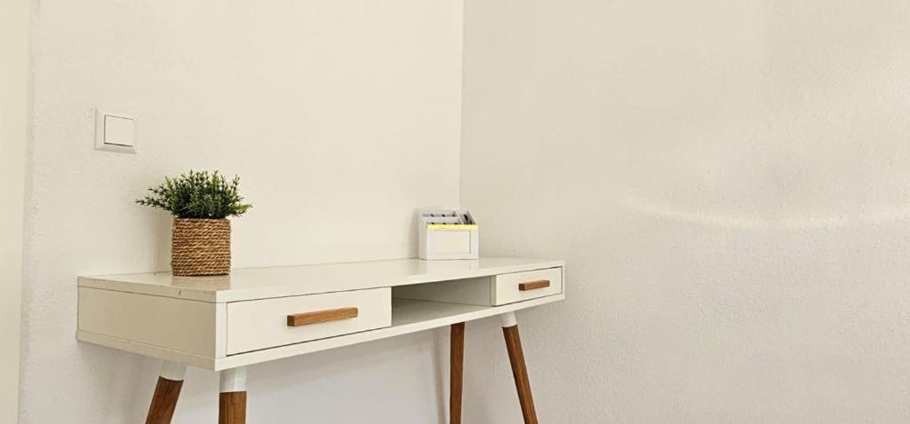 a white dresser with a potted plant on top of it at Timeless: 4 Zimmer Apartment OG Ludwigsburg in Ludwigsburg