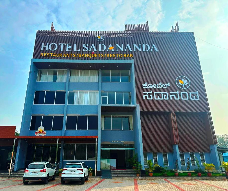 a building with cars parked in front of it at Sadanand's Highway Inn, Tumkur in Tumkūr
