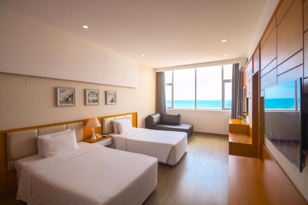ein Hotelzimmer mit 2 Betten und einem TV in der Unterkunft Sammy Hotel in Vũng Tàu