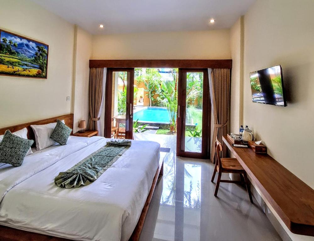 Un dormitorio con una cama grande y un escritorio con un escritorio. en tiny's house, en Ubud