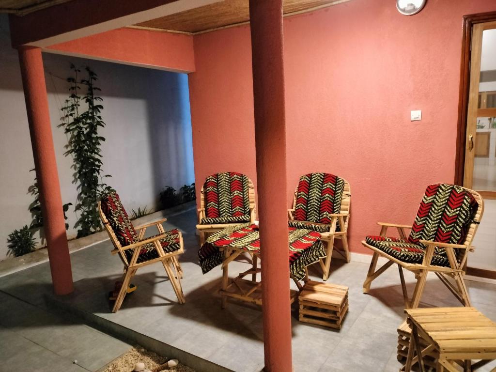 a group of chairs in a room with red walls at Ker Vento in Rufisque