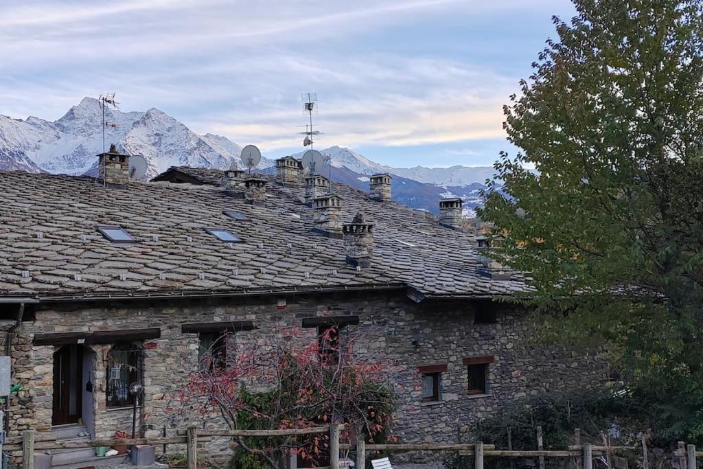 an old stone building with mountains in the background at Relais du Bourg in Roisan