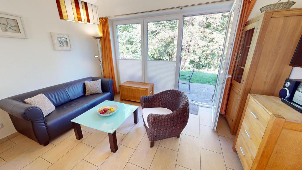 a living room with a couch and a table at Feriendorf Südstrand Haus 21 in Pelzerhaken