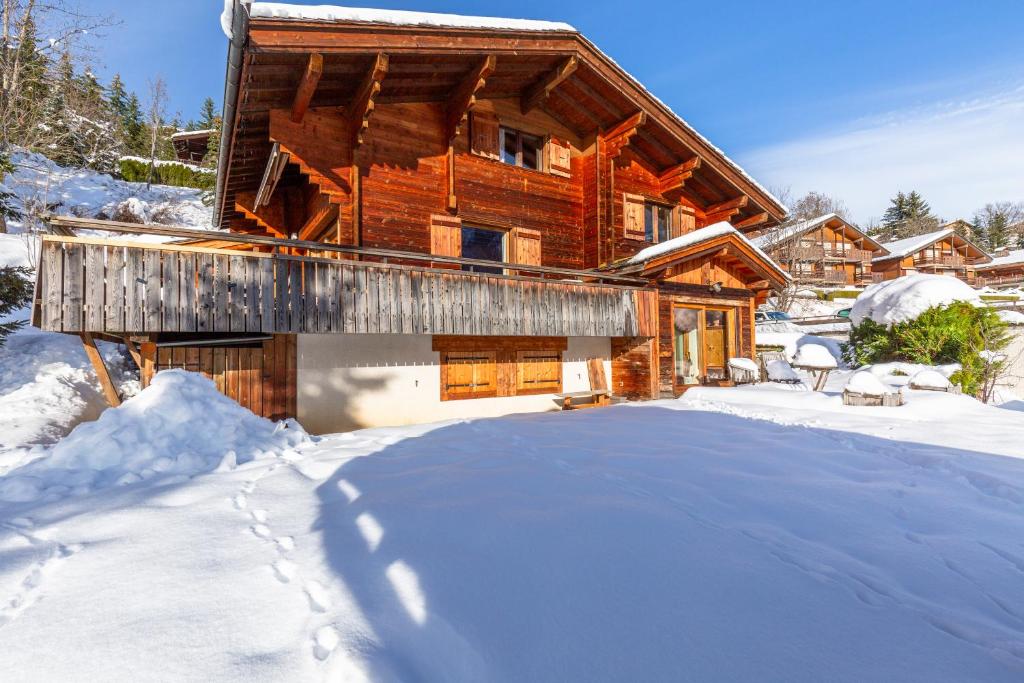 a log cabin in the snow with a driveway at Chalet Coelacanthe in La Clusaz