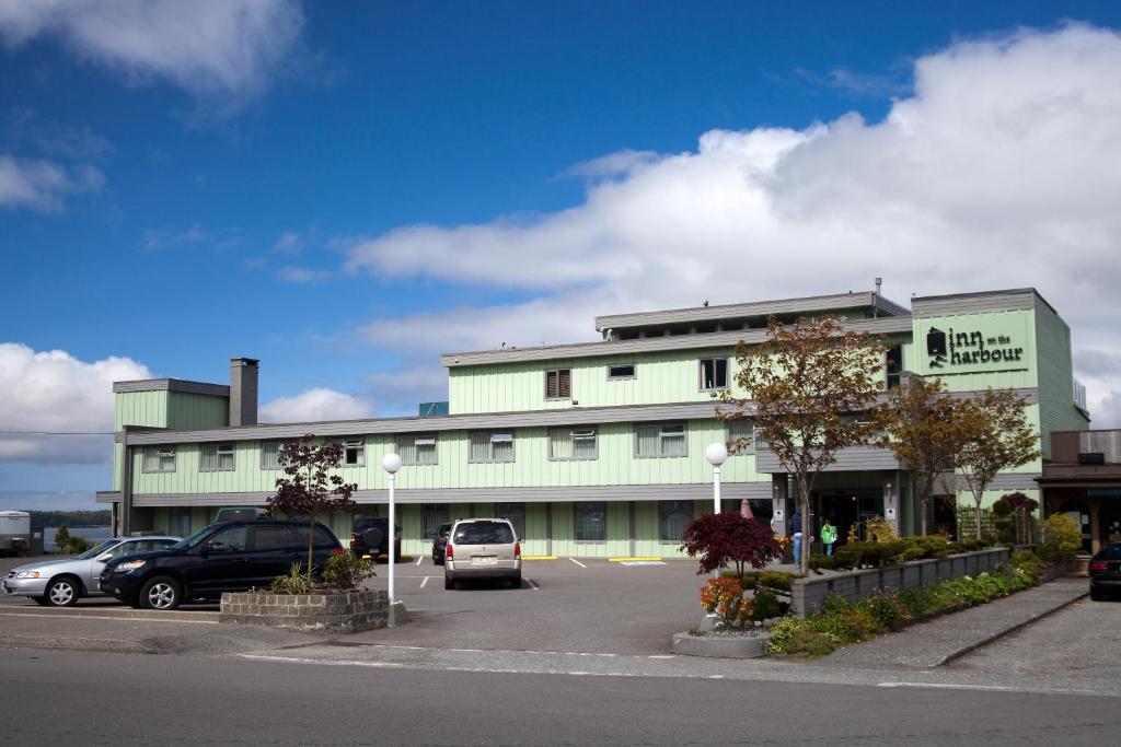 a large white building with cars parked in a parking lot at Inn on the Harbour in Prince Rupert