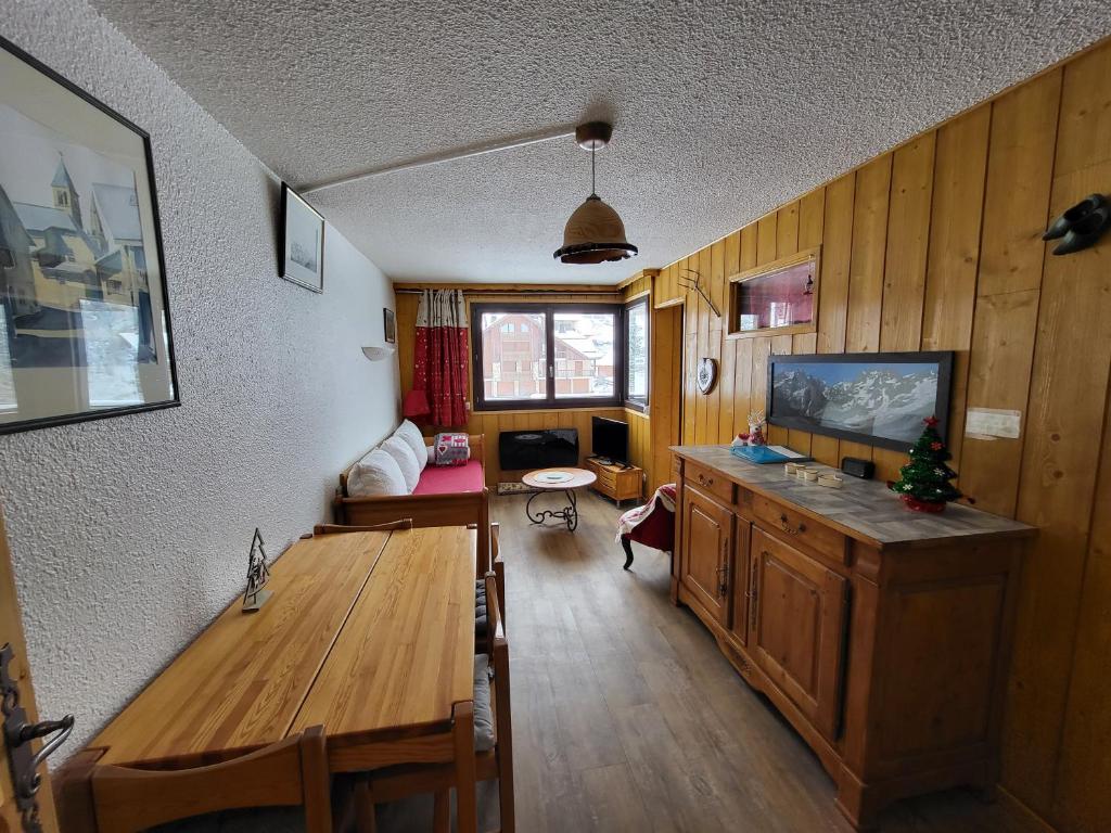 salon z drewnianym stołem i telewizorem w obiekcie Les Mélèzes w mieście Saint-Chaffrey