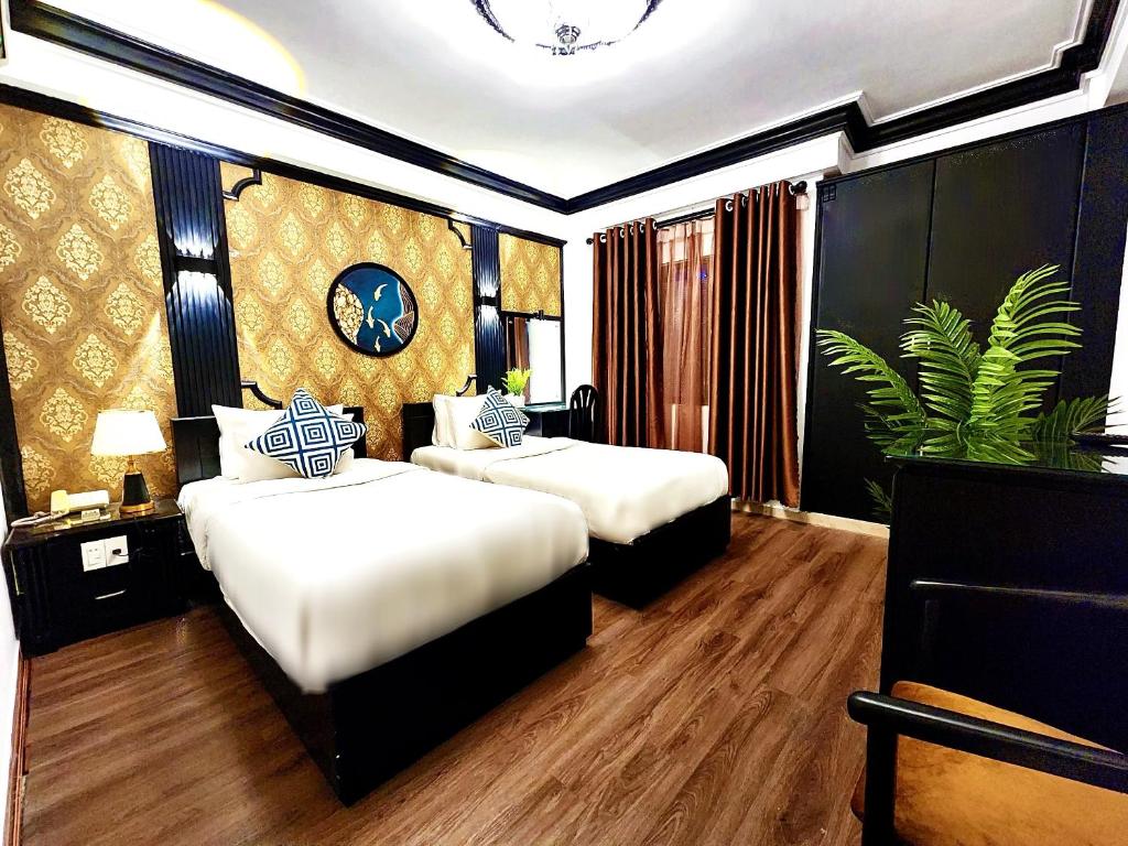 um quarto com duas camas e uma planta nele em ROSA ZEN Hotel Spa em Ho Chi Minh