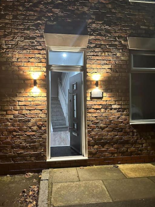 a brick wall with a door and a staircase at 4 Bedroom Detached House in Liverpool