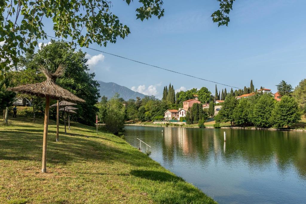 Un río con una sombrilla junto a un lago en Camping les Rives du Lac de Vinça, en Vinça