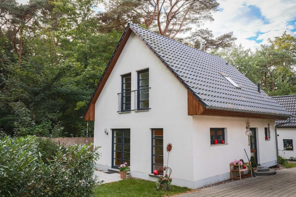 a white house with a black roof at Kölp - Wald und Mee h r in Kölpinsee