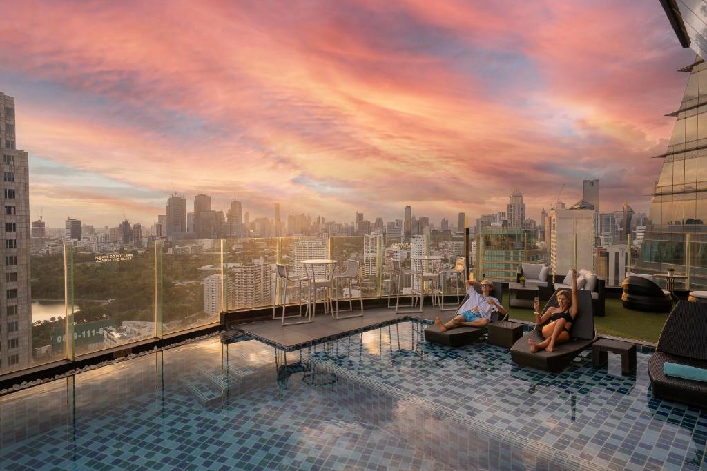 ein Pool auf dem Dach mit einer Skyline der Stadt in der Unterkunft The Continent Hotel Sukhumvit - Asok BTS Bangkok by Compass Hospitality in Bangkok