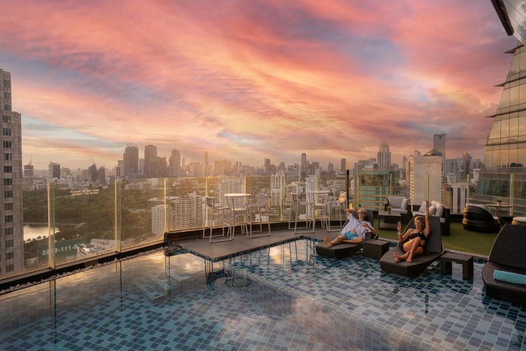 バンコクにあるThe Continent Hotel Sukhumvit - Asok BTS Bangkokの市街のスカイラインを望む屋上プールのレンダリング