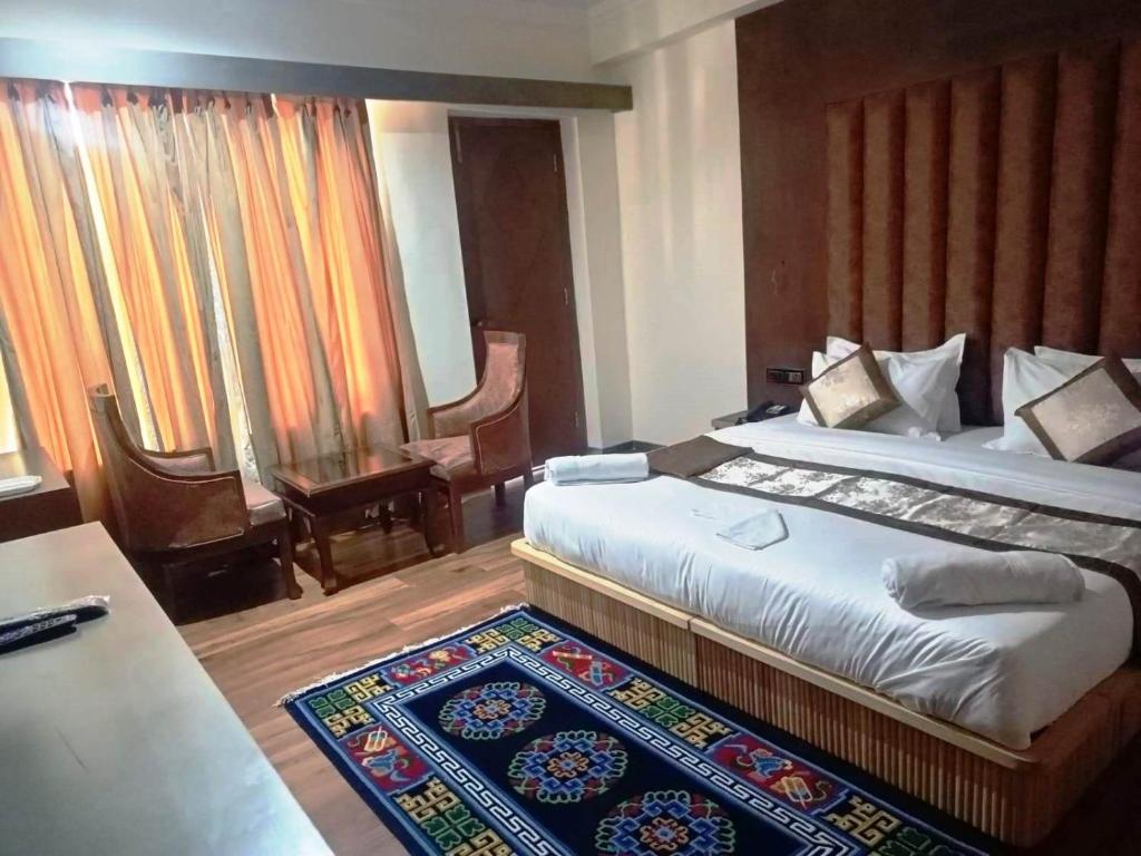 a bedroom with a king sized bed and a rug at Hotel Ladakh Heaven in Leh