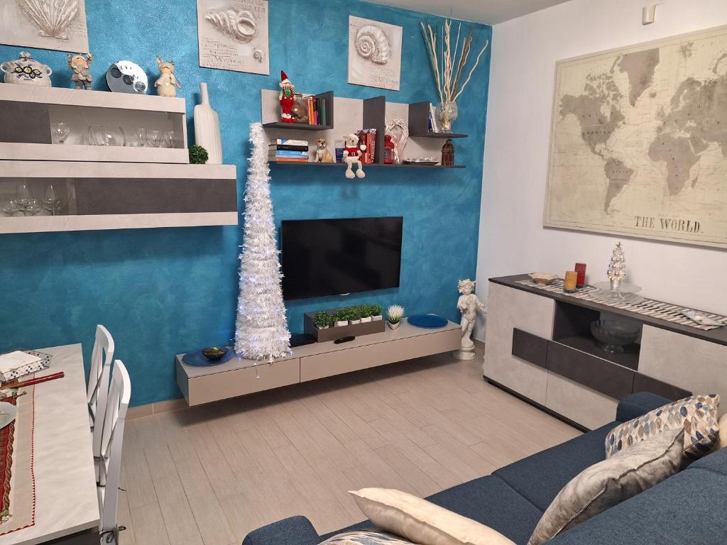a living room with a television and a christmas tree at leupupe relax cultura mare monti in Cascina
