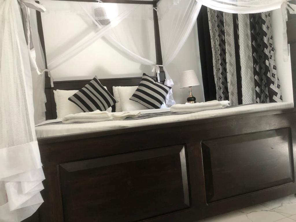 un letto con cuscini bianchi e neri e uno specchio di skyresort a Tangalle