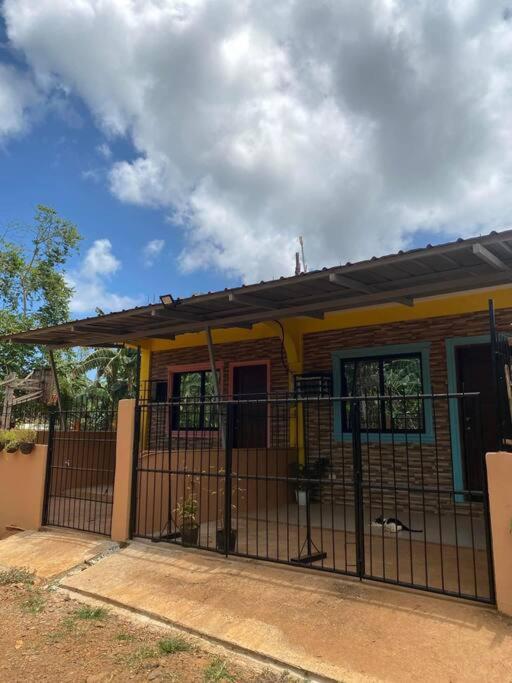 ein Haus mit einem Tor davor in der Unterkunft Friendly Transient House in Puerto Princesa