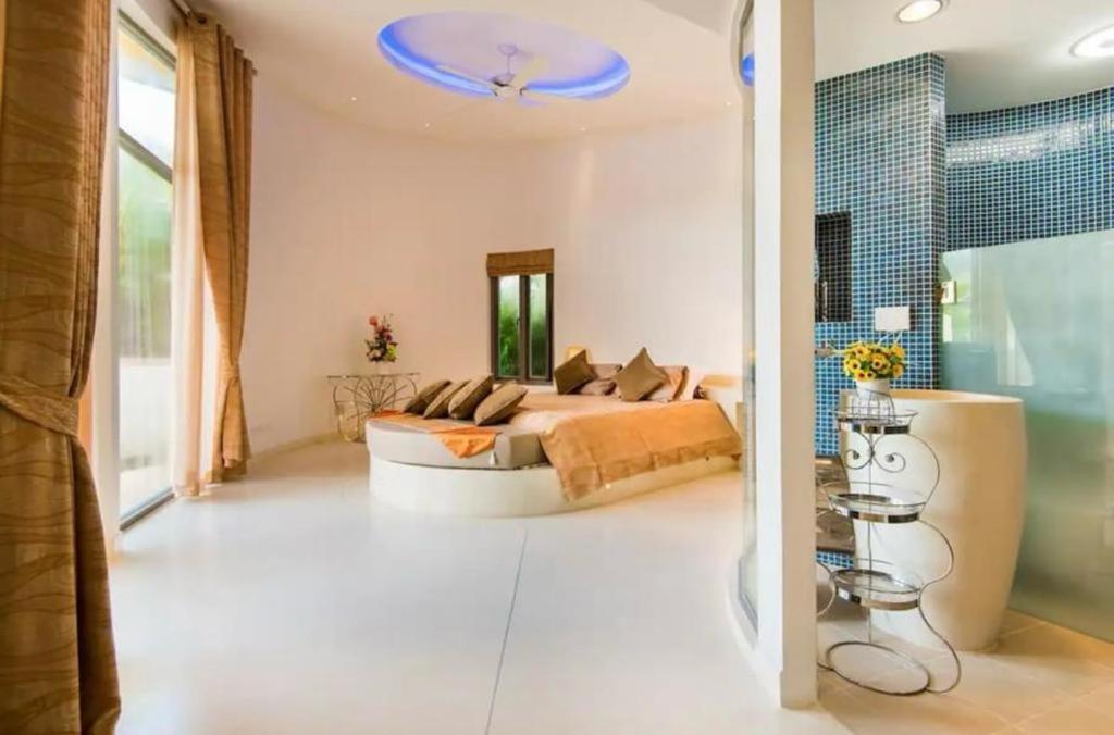 a bedroom with a bed and a blue ceiling at Butterfly Villa in Ban Tha Maphrao
