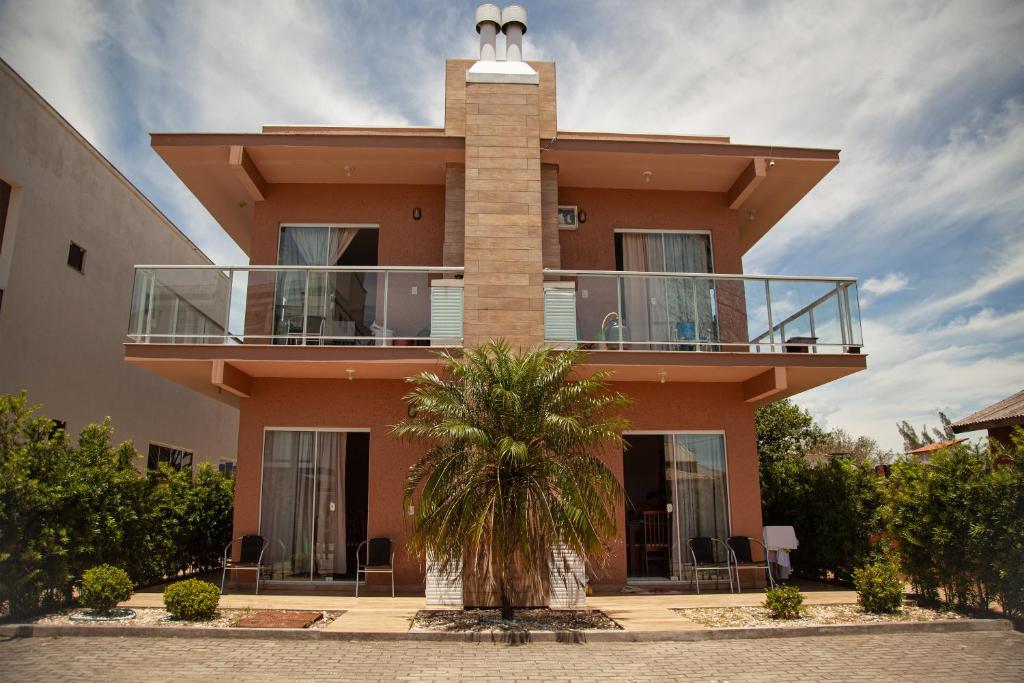 a building with a balcony and a palm tree in front at Residencial Beija-Flor in Palhoça