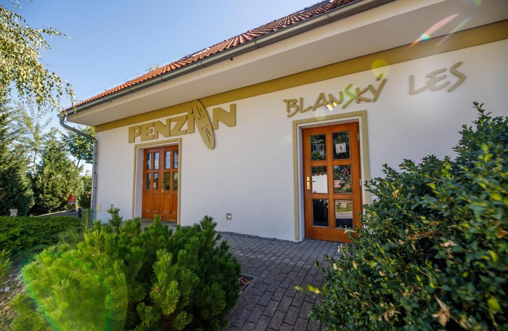 a white building with a sign that reads play n playay les at Penzion Blanský Les in Dubné