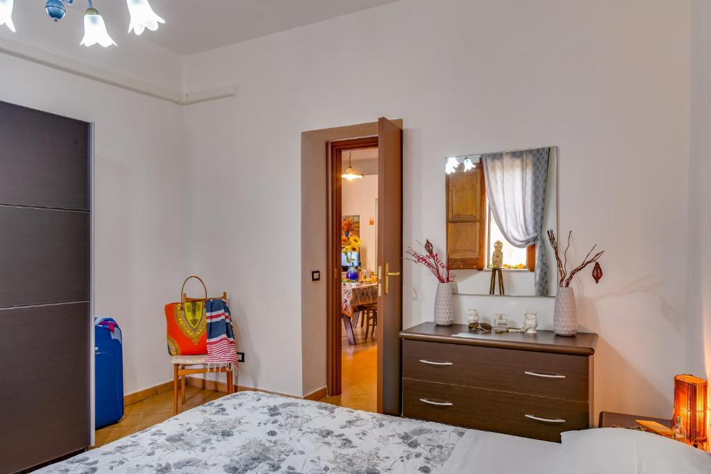 a bedroom with a bed and a dresser and a mirror at Case Vacanze Castellana Iris in Sciacca