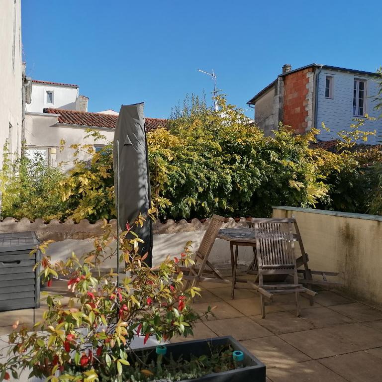 a patio with a table and chairs and plants at L Appart des Cloutiers in La Rochelle