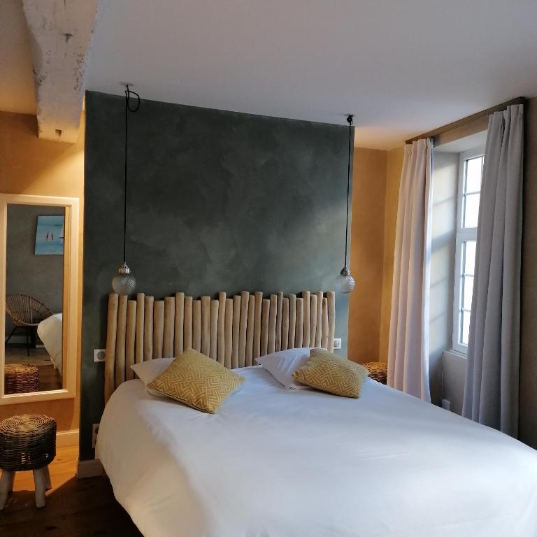 a bedroom with a large white bed with two pillows at L Appart des Cloutiers in La Rochelle
