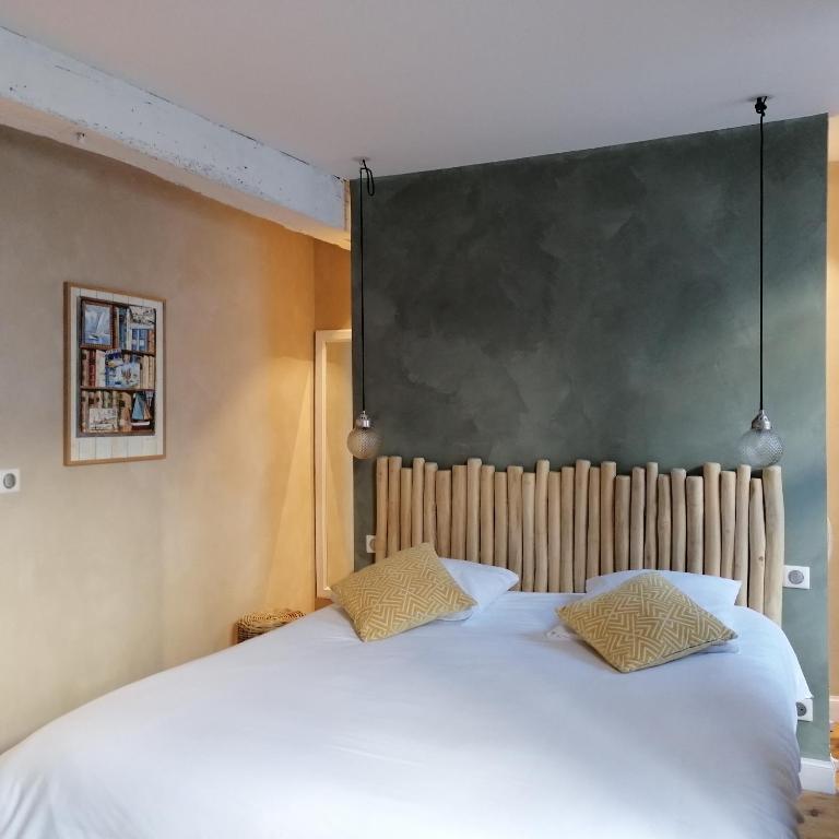 a bedroom with a large white bed with two pillows at L Appart des Cloutiers in La Rochelle