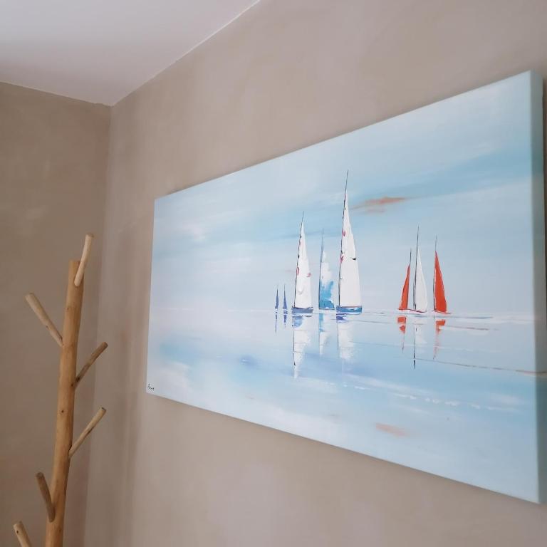 a painting of sailboats on the water on a wall at L Appart des Cloutiers in La Rochelle