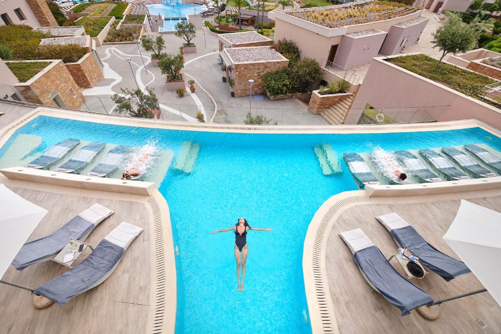 Una donna è in acqua in una piscina di Miraggio Thermal Spa Resort a Paliouri