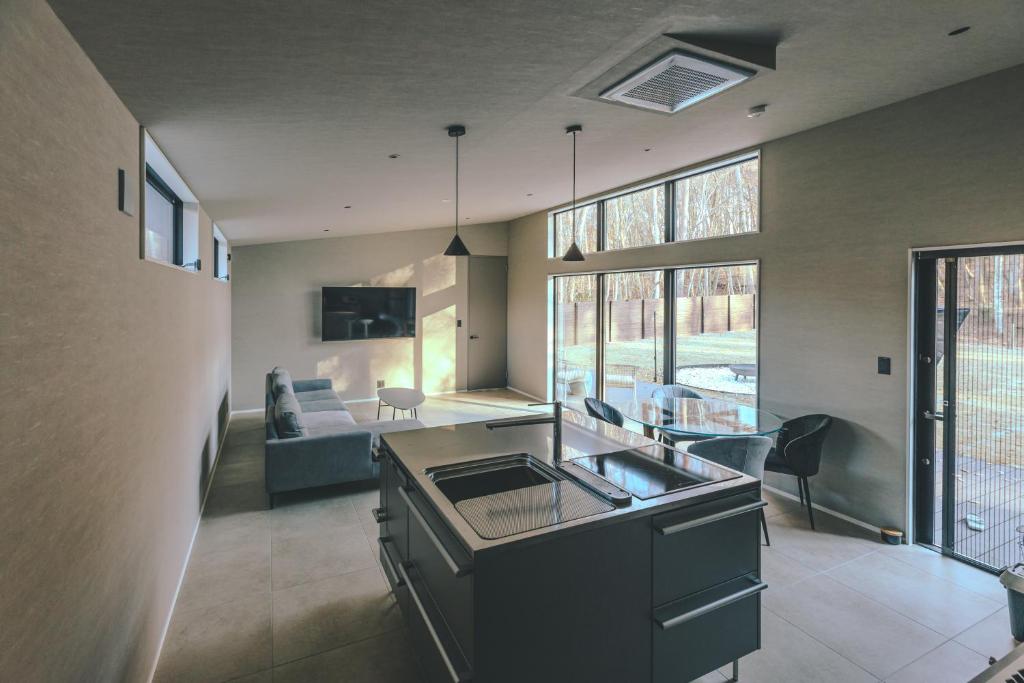 a kitchen and living room with a couch and a table at ASH Villa Fujikawaguchiko in Fujikawaguchiko