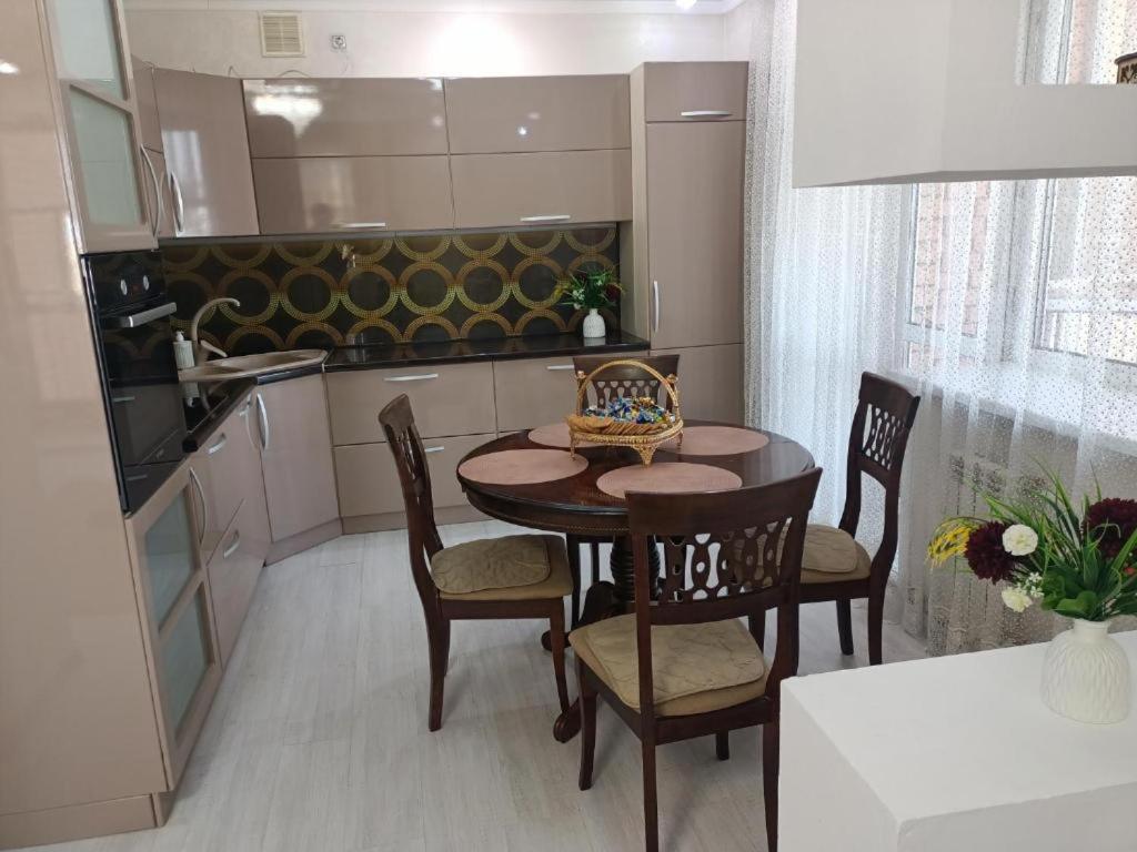 a kitchen with a table and chairs in a kitchen at ВИП КВАРТИРЫ in Kokshetau