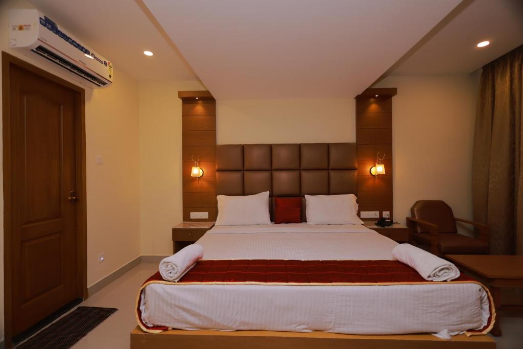 a bedroom with a large bed in a room at Hotel Sangam in Kanyakumari