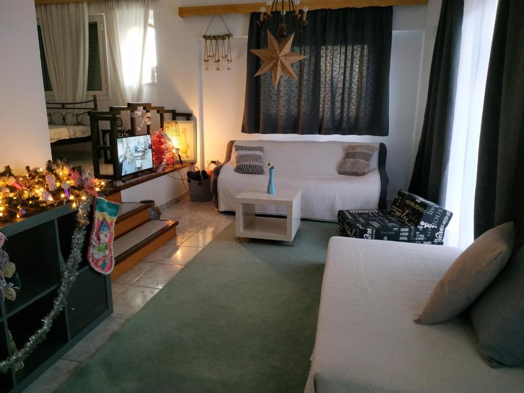 uma sala de estar com uma cama branca e uma televisão em SandyKosta em Kiáton